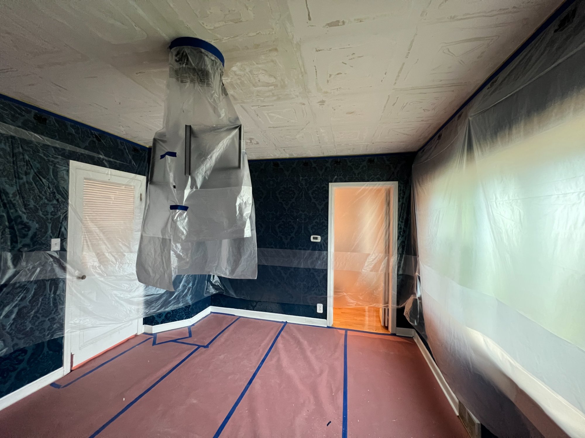 Room prepped with plastic sheeting for ceiling drywall repair in Manitowoc