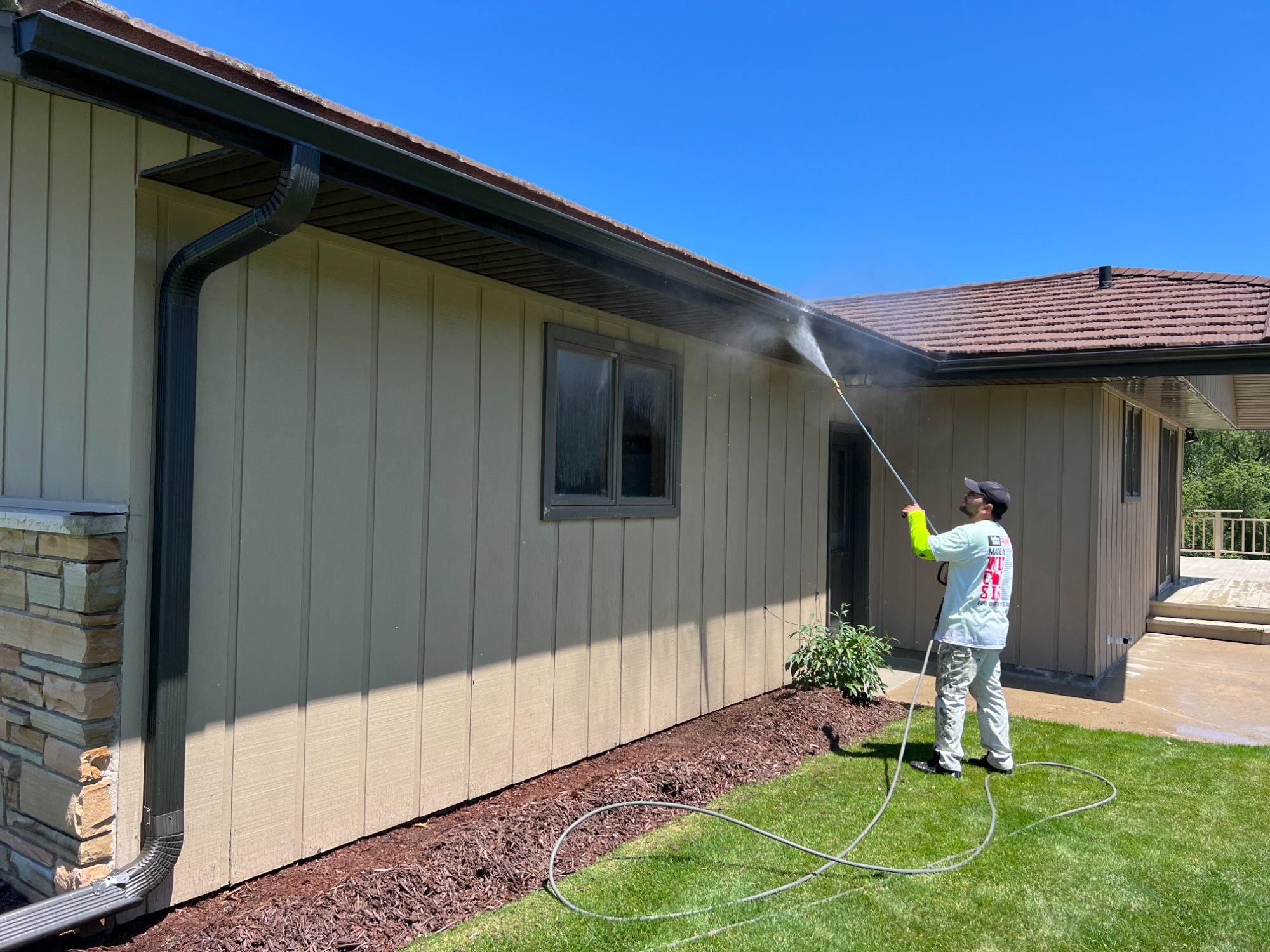 Power washing exterior siding of ranch home in Manitowoc County